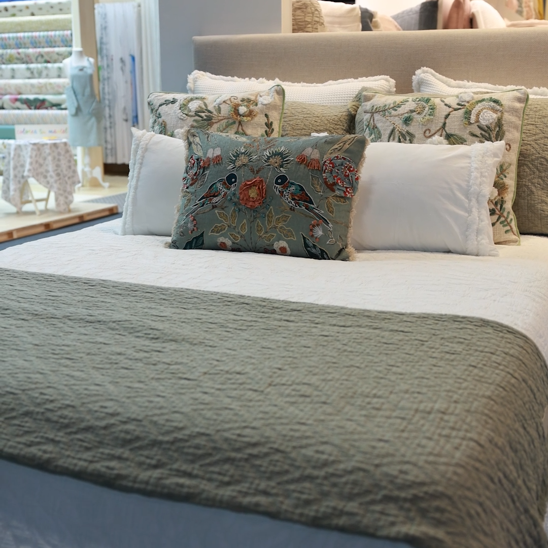 Colcha blanca con plaid verde agua y cojines bordados