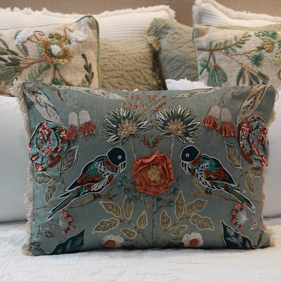 Detalle cojín bordado con pájaros y elementos naturales