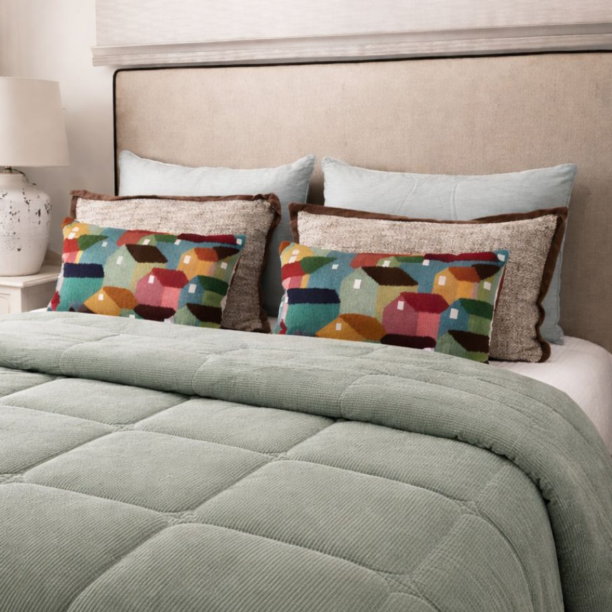 Colcha verde agua con cojines coloridos, estampados y lisos